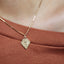 Gold necklace with a pendant on a brown surface