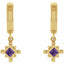 Gold earrings with purple gemstones on a white background