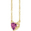 Gold necklace with a heart-shaped pink gemstone on a white background