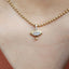 Gold necklace with a diamond pendant on a person's neck