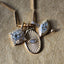 A product picture of a marquise diamond eye pendant. This pendant is made of solid gold, bezel set with two layers with ray pattern on the inner most layer. This pendant also has a four diamond bail and a gold tear drop. Photo showing with other diamond charms.