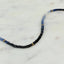 A sapphire necklace with an ombre look, created with different shaded green and gold bead spacing.