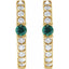 Gold earrings with green gemstones and clear stones on a white background