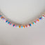A rainbow colored opal strand beaded necklace made with gold filled wheel clasp.