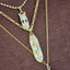 Gold necklace with gemstones on a brown fabric background