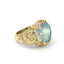 Gold ring with a large blue gemstone and floral designs on a white background