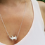 A sterling silver realistic hammer head shark pendant with a silver cable chain attached to the head and tail making it a lively necklace.