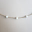 A pearl station necklace with fresh water pearls stationed with rolo link chain segments in between.