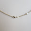 A pearl station necklace with fresh water pearls stationed with rolo link chain segments in between. Clasp