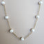 A pearl station necklace with fresh water pearls stationed with rolo link chain segments in between.