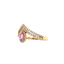 A crown shaped ring with a pink sapphire set in the center. The band is pave set with diamonds with a halo.