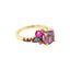 A colored gemstone cluster ring with a pink and purple color palate. Made with different hues and sizes of round colored gemstones set on a gold band.