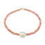 A faceted ombre beaded necklace with a large oval pearl in the center with two accent beads and round clasp.
