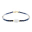 A faceted ombre beaded necklace with a large oval pearl in the center with two accent beads and round clasp.