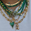 Product picture of a heart pendant with a colored gemstone in lay and a diamond pave boarder. Shown on a curb chain.