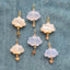 A storm cloud pendant with a hand carved gemstone and a solid gold charm attached at the bottom of the cloud.