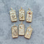 A tarot card inspired pendant with different face card designs such as love, rose, hourglass, the sun, the moon, the stars, and courage.