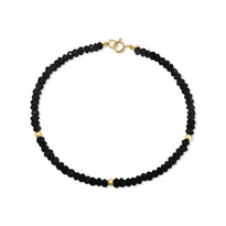 A faceted beaded gemstone bracelet with three gold bead accents and lobster clasp. Available in twelve natural gemstones. 