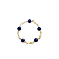 Gold bracelet with blue beads on a white background