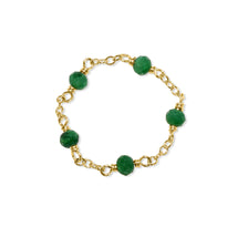 Gold bracelet with green beads on a white background
