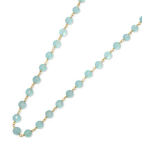 A blue gemstone beaded station necklace with yellow gold.