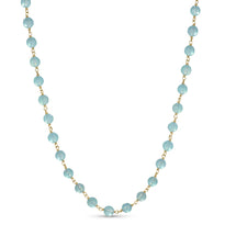 A blue gemstone beaded station necklace with yellow gold.