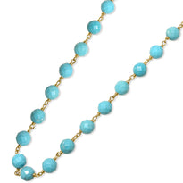 A blue gemstone beaded station necklace with yellow gold.