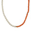 A beaded necklace with oval or bean shaped fresh water pearls and round pink coral beads. Finished with a round clasp.