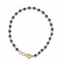Gold necklace with blue gemstones on a white background