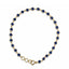 Gold necklace with blue gemstones on a white background