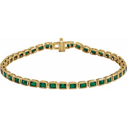 Gold bracelet with green gemstones on a white background