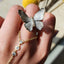 Butterfly-shaped jewelry on a light green flower