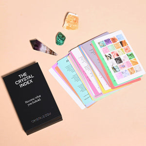 Crystal index book with colorful pages and crystals on a beige background