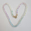A clear faceted crystal quartz beaded necklace with rainbow dyed threads hand knotted so the colors can be magnified. 