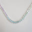 A clear faceted crystal quartz beaded necklace with rainbow dyed threads hand knotted so the colors can be magnified. 