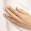 Hand wearing a gold ring on a white background