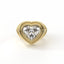 Gold heart-shaped diamond ring on a white background