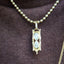 Gold necklace with a pendant on a brown fabric background