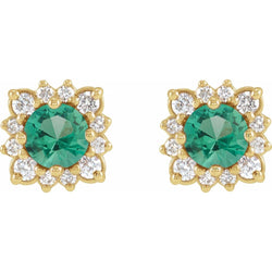 Gold earrings with green gemstones and clear stones on a white background