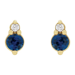 Gold earrings with blue gemstones and clear stones on a white background