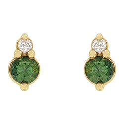 Gold earrings with green gemstones and clear stones on a white background