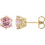 Gold earrings with pink gemstones on a white background