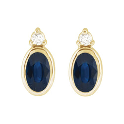 Gold earrings with blue stones and clear gemstones on a white background