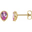 Gold earrings with pink gemstones on a white background