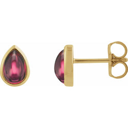 Gold earrings with teardrop-shaped red gemstones on a white background