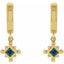 Gold earrings with blue gemstones on a white background