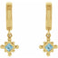 Gold earrings with blue gemstones on a white background