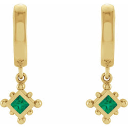 Gold earrings with green gemstones on a white background