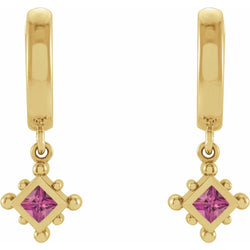 Gold earrings with pink gemstones on a white background
