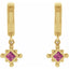 Gold earrings with pink gemstones on a white background